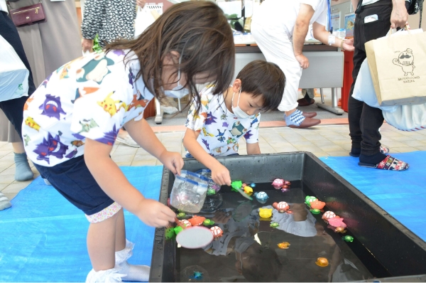 光る金魚すくいをする子供